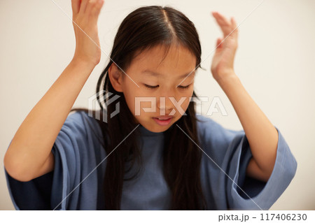 夏休みの小学生の女の子が宿題に悩む様子 夏休みの小学生の女の子が宿題に悩む様子 117406230