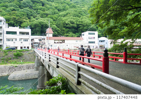 箱根湯本駅前すぐの赤い橋(あじさい橋)を手をつないだカップルが歩いている 箱根湯本駅前すぐの赤い橋(あじさい橋)を手をつないだカップルが歩いている 117407448