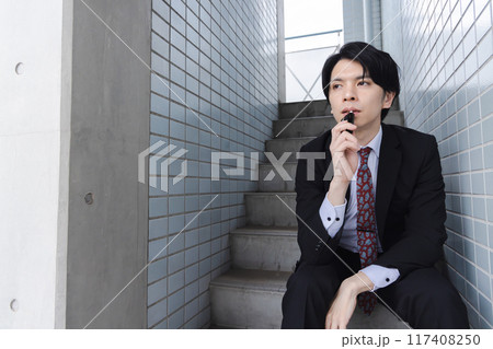 非常階段で電子煙草を吸うビジネスマン 117408250
