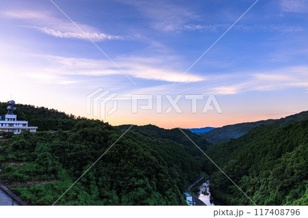 2024年夏布目ダム北(布目川)方向の夕景　山際に広がる夕焼けと深い青に染まっていく空① 117408796