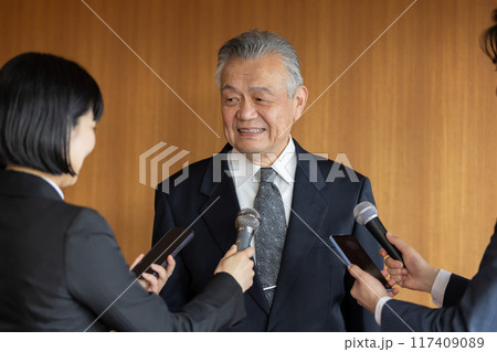 報道陣の質疑応答に応えるシニアビジネスマン 117409089