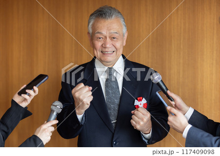 報道陣の質疑応答に応えるシニアビジネスマン 117409098