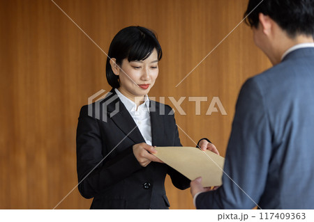 社外秘の封筒を渡すビジネスマン 117409363