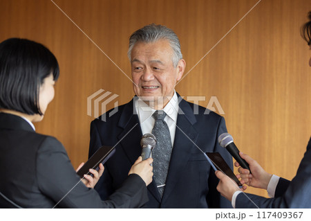 報道陣の質疑応答に応えるシニアビジネスマン 117409367