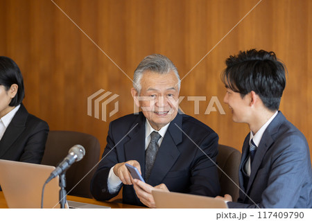 会議中にスマホを使うシニアビジネスマン 117409790