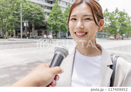 インタビューを受けるビジネスウーマン（取材・マイク） 117409952