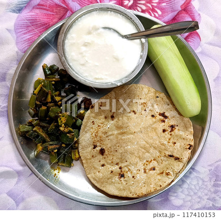 Indian Cuisine Bhindi or okra curry and Roti or chapati with curd served in a plate. selective focus 117410153