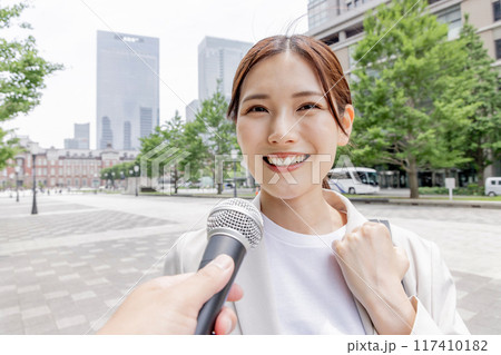 インタビューを受けるビジネスウーマン（取材・マイク） 117410182