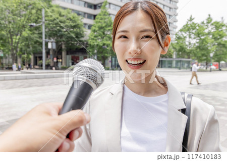 インタビューを受けるビジネスウーマン（取材・マイク） 117410183