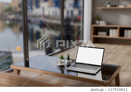 A laptop computer mockup on a coffee table in a contemporary minimalist apartment. 117410621