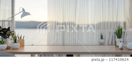 A copy space for displaying products on a wooden table by the window in a contemporary room. A copy space for displaying products on a wooden table by the window in a contemporary room. 117410624