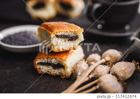 Sweet bun with poppy seed on black table. Sweet bun with poppy seed on black table. 117412874