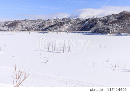 北海道夕張市、全面結氷したシューパロ湖に架かる白銀橋と夕張岳・前岳【1月】 117414493