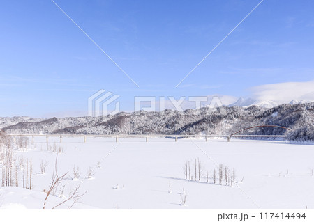 北海道夕張市、全面結氷したシューパロ湖に架かる白銀橋と夕張岳・前岳【1月】 117414494