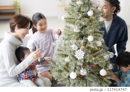クリスマスツリーの飾り付けをする家族　母と父と娘と赤ちゃん 117414747