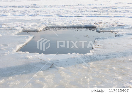 A pond in the icy lake in the form of a cross for the feast of the baptism of the Lord 117415407