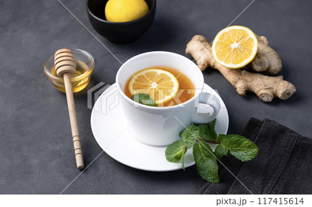 Cup of tea with lemon, honey and mint on a dark background. The concept of a healthy drink  117415614