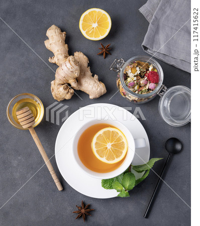 Flat lay herbal cup of tea with lemon, honey and mint on a dark background.  117415622