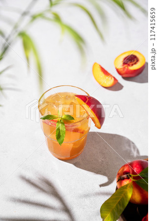 Refreshing peach tea with ice and mint. Homemade cold healthy vegetarian drink on a light background 117415659