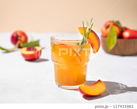 Refreshing peach tea with ice and rosemary. Homemade cold healthy vegetarian drink Refreshing peach tea with ice and rosemary. Homemade cold healthy vegetarian drink 117415862