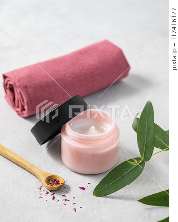 Face and body cream on a light background close up. The concept of care cosmetics with rose Face and body cream on a light background close up. The concept of care cosmetics with rose 117416127