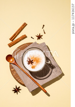 Traditional Indian masala chai latte in a glass cup. Hot drink with milk, spices and herbs 117416137