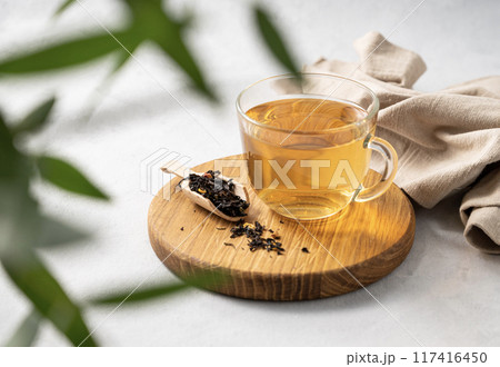 Fragrant herbal tea in a glass cup on a cutting board and white background with eucalyptus Fragrant herbal tea in a glass cup on a cutting board and white background with eucalyptus 117416450