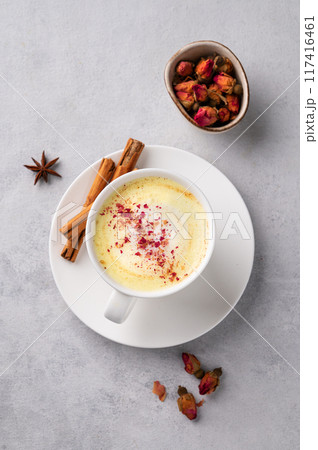 Golden milk latte with turmeric and rose petals. Trendy Indian drink Moon milk with natural spices. Golden milk latte with turmeric and rose petals. Trendy Indian drink Moon milk with natural spices. 117416461