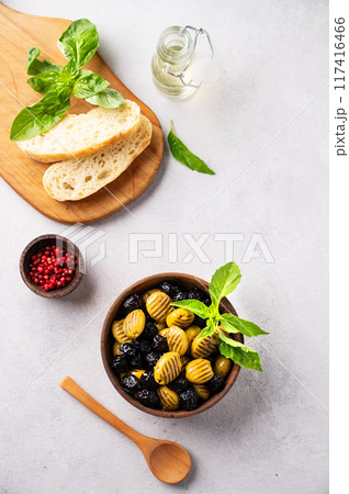 A set of green and black dried olives in wooden bowl  with fresh chiabatta bread  117416466