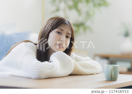 部屋でくつろぐニットの若い女性 117416553