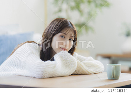 部屋でくつろぐニットの若い女性 117416554