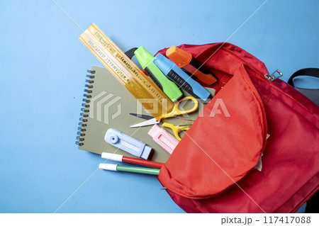 A red backpack with a ruler, scissors, and other school supplies A red backpack with a ruler, scissors, and other school supplies 117417088