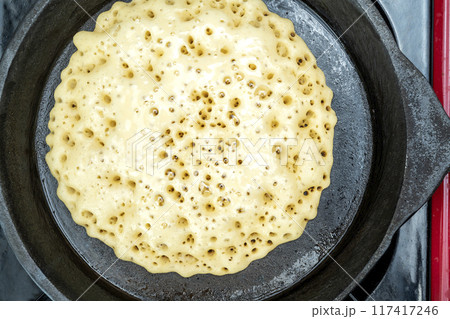A pan of batter is cooking on a stove A pan of batter is cooking on a stove 117417246