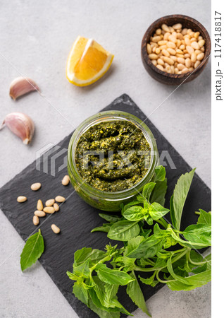 Traditional Italian pesto in a jar with green basil, pine nuts, cheese and olive oil 117418817