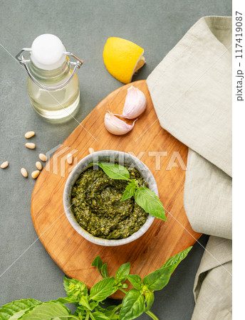 Traditional Italian pesto in a bowl with green basil, pine nuts, cheese and olive oil  117419087