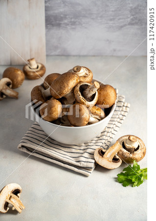 Raw champignon in a bowl on bright background, button mushrooms. Vegan protein.  117420915