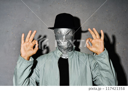 Mystery man with duct tape face doing ok sign with hand and fingers 117421358