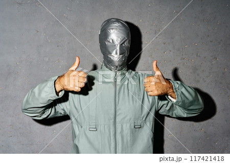 Mystery man with duct tape face showing thumbs up sign 117421418