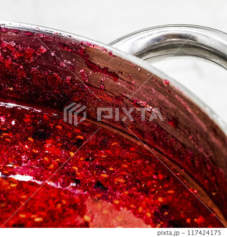 Cooking raspberry jam 117424175