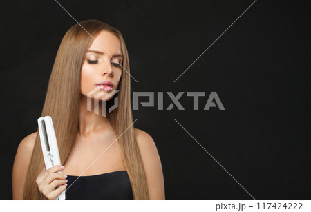 Face of fashion model woman using hair straighteners iron on white background. Harstyle, hair care Face of fashion model woman using hair straighteners iron on white background. Harstyle, hair care 117424222