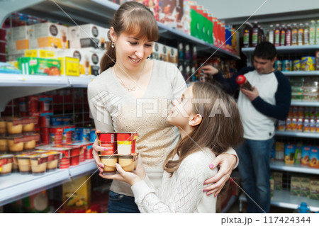 Woman with daughter buying sweet yoghurts Woman with daughter buying sweet yoghurts 117424344