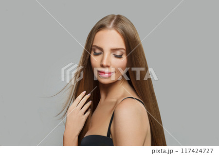 Cheerful female model brunette with long hair and natural make-up posing isolated 117424727
