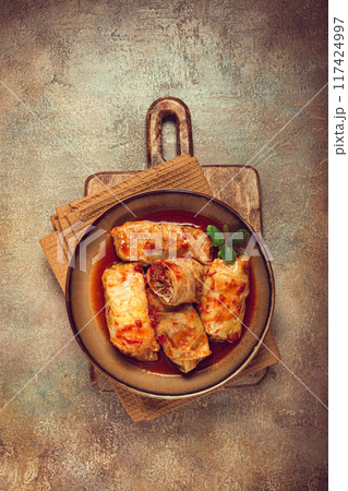Stuffed cabbage rolls with minced meat, in tomato sauce, top view, without people, in the spotlight. Stuffed cabbage rolls with minced meat, in tomato sauce, top view, without people, in the spotlight. 117424997
