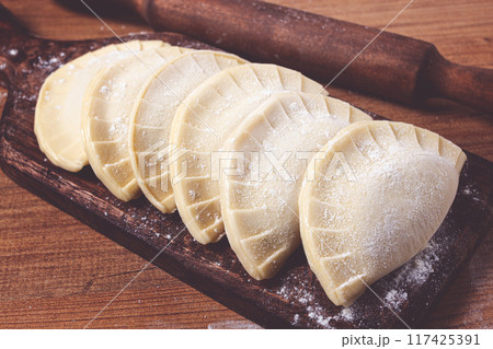 raw chebureks, mini, on a cutting board, wooden table, close-up, no people, raw chebureks, mini, on a cutting board, wooden table, close-up, no people, 117425391
