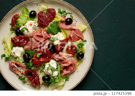 salad with dried tomatoes, prosciutto, soft cheese, olives, homemade, top view, salad with dried tomatoes, prosciutto, soft cheese, olives, homemade, top view, 117425396