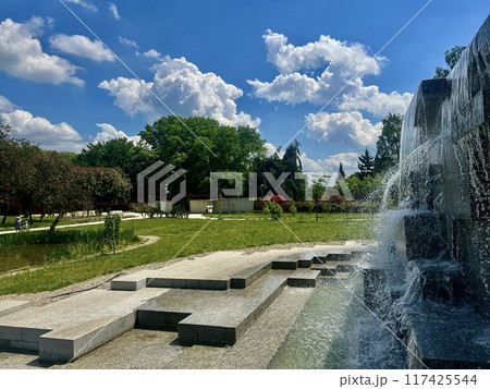 Fountain in the park on a background of blue sky with clouds. Japanese garden at Silesian park, Chorzow, Poland 117425544