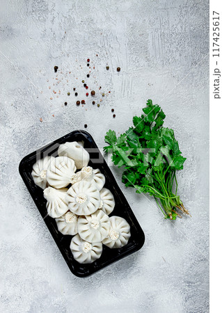 freshly frozen, raw khinkali, in a black plastic container, Georgian cuisine, top view, no people, freshly frozen, raw khinkali, in a black plastic container, Georgian cuisine, top view, no people, 117425617