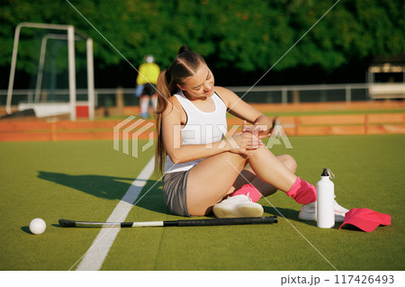 girl hockey player plays field hockey on a sunny day, a hockey player was injured in a game of field hockey 117426493