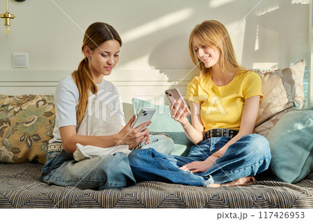 Two teenage girls students 17, 18 years old with smartphones in hands Two teenage girls students 17, 18 years old with smartphones in hands 117426953