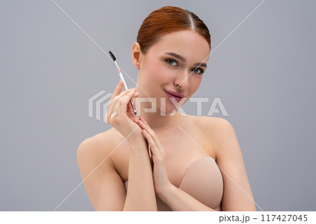 Attractive woman enhancing brows with cosmetic brush Attractive woman enhancing brows with cosmetic brush 117427045